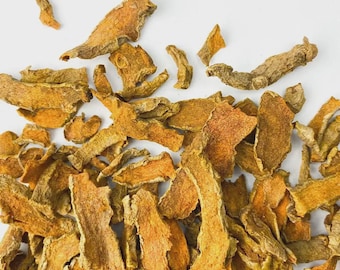May include: A collection of dried turmeric root pieces, varying in size and shape, against a white backdrop. The pieces display a range of colours, from pale tan to vibrant orange. The texture is rough and uneven, emphasizing the natural characteristics of the spice.