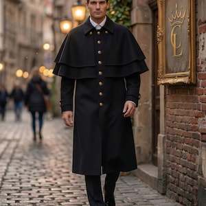 May include: A long black wool coat featuring a double-layered capelet shoulder design, a high collar, and a front button closure with metallic gold-toned buttons. The coat is worn over a white collared shirt and dark trousers with black dress shoes.