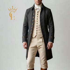 May include: A dark gray wool coat with gold buttons, worn over a cream-colored vest and pants. The outfit includes a white bow tie and a long coat with buttoned cuffs. The ensemble is reminiscent of historical formal wear.