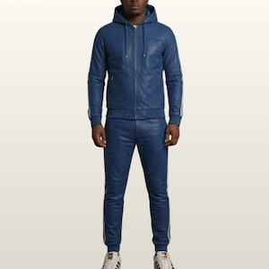 May include: A blue leather hooded jacket with a front zipper and matching blue leather joggers. Both pieces feature white side stripes. The jacket has a drawstring hood and ribbed cuffs, while the pants have a fitted waistband and ribbed ankles.
