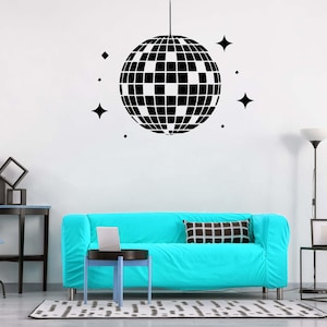 May include: A black and white disco ball wall decal with a white background. The decal is on a white wall above a turquoise couch with a black and white patterned pillow. There is a black side table with a black lamp and a black and white picture frame on the table.