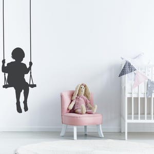 Swing wall decal showing a child silhouette on a rope swing, created to add a soft nostalgic moment that feels like quiet joy suspended in time.