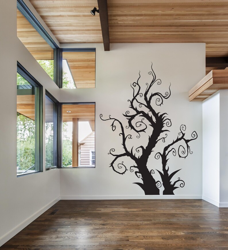 Curly branch decor designed with layered, swirling limbs that feel pulled from a fairytale illustration or fantasy sketch. Whimsical silhouette of a tree with twisting branches and swirling vines. The tree is a wall decal and is a great way to add a touch of whimsy to any room.