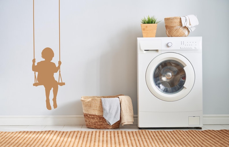 Child on swing wall decal rendered in a classic silhouette style, bringing a sense of innocence and the memory of carefree afternoons into the room.