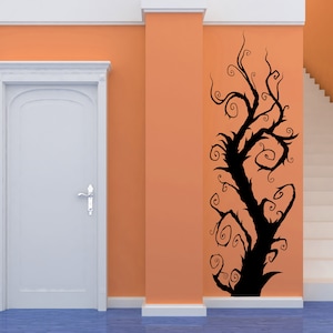 A tree with twisting branches and swirling vines on an orange wall. The tree is a wall decal.