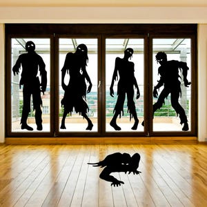 Puede incluir: Cinco siluetas negras de zombies están en una ventana. Los zombies están en varias poses, con los brazos extendidos y las piernas dobladas. La ventana es de vidrio y tiene un marco de madera. Hay una silueta negra de un zombie en el suelo frente a la ventana.