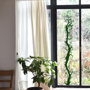Gothic tree decor uses elongated branches and dramatic curves to create a bold silhouette that feels imaginative and visually engaging. Window decal sticker.