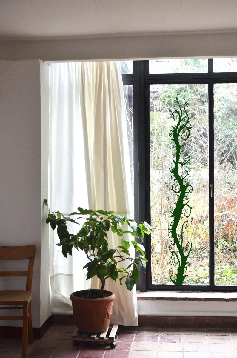 Gothic tree decor uses elongated branches and dramatic curves to create a bold silhouette that feels imaginative and visually engaging. Window decal sticker.