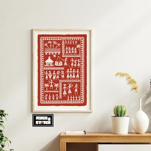 May include: Framed red artwork with white tribal figures and symbols. The art piece features a series of stylized human figures, trees, and geometric shapes. The artwork is displayed in a light-colored wooden frame, adding a touch of rustic charm.
