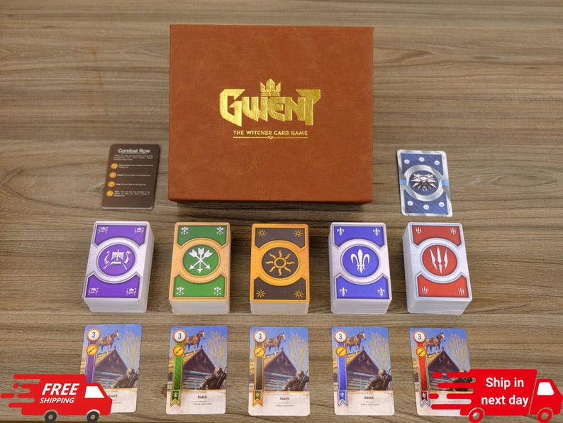 Puede incluir: Un juego de cartas Gwent en caja marr&oacute;n, con el texto "Gwent The Witcher Card Game" en letras doradas. El juego incluye varias barajas de cartas con varios s&iacute;mbolos e ilustraciones, y una peque&ntilde;a tarjeta de instrucciones. Las cartas est&aacute;n dispuestas sobre una superficie de madera.