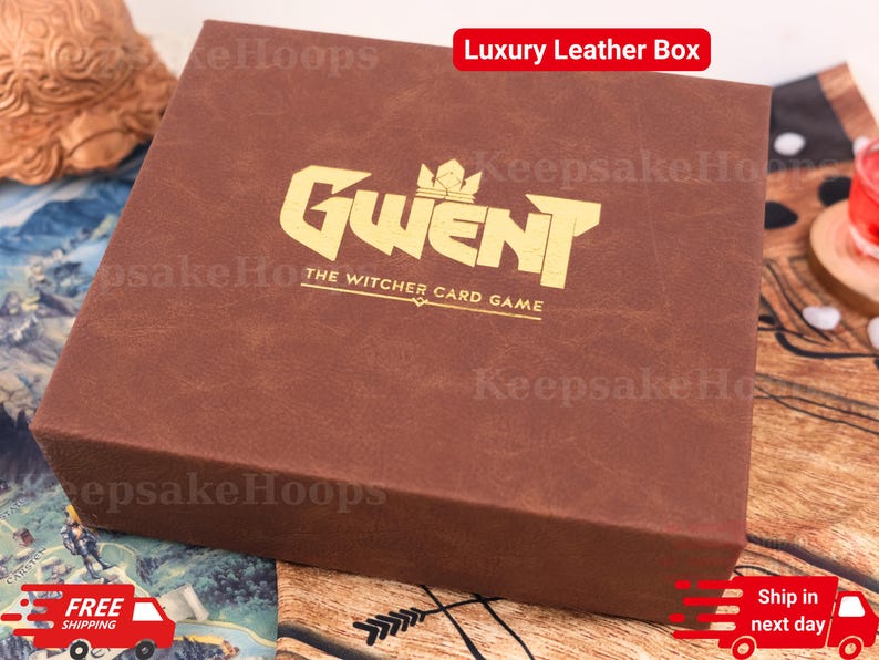 Puede incluir: Una caja de cuero marr&oacute;n con el texto dorado "GWENT THE WITCHER CARD GAME" en la parte superior. La caja tiene una superficie texturizada y las palabras "Luxury Leather Box" est&aacute;n en un rect&aacute;ngulo rojo. La caja est&aacute; sobre una superficie estampada.