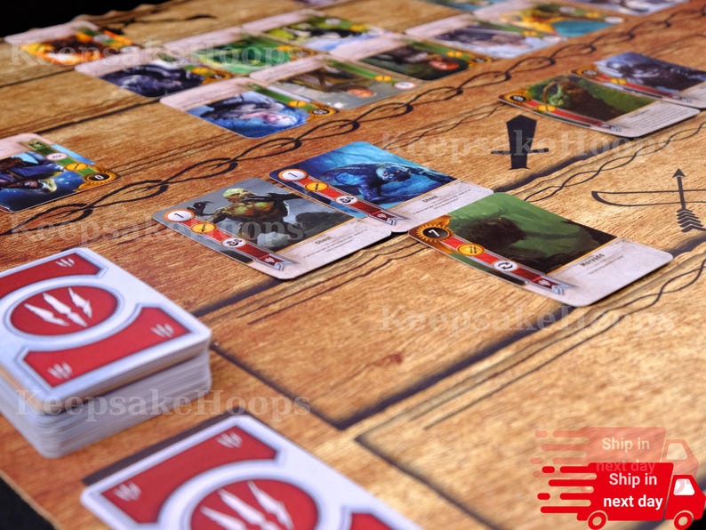 Puede incluir: Configuraci&oacute;n de un juego de mesa con cartas ilustradas y un tapete de juego con efecto de madera. Las cartas muestran im&aacute;genes y texto, con un emblema rojo y blanco en el reverso. El tapete de juego tiene gr&aacute;ficos relacionados con el juego.