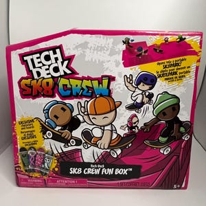 May include: A Tech Deck Sk8 Crew Fun Box toy set in a pink and white cardboard package. The box features cartoon characters on skateboards, a graphic of a portable skatepark, and the text Tech Deck Sk8 Crew and Sk8 Crew Fun Box.