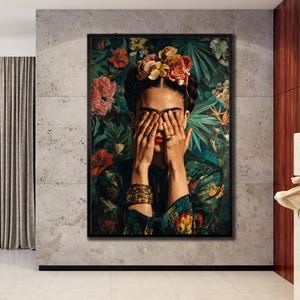 May include: A framed rectangular wall art print featuring a portrait of a person with dark hair adorned with colorful flowers. The person has their hands covering their eyes, wearing stacked bracelets and rings, set against a lush green foliage background.