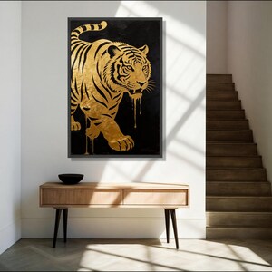 May include: A rectangular wall art piece featuring a gold tiger silhouette against a solid black background. The tiger is depicted in a walking pose with black stripes and gold paint dripping from its body, all enclosed within a thin black frame.