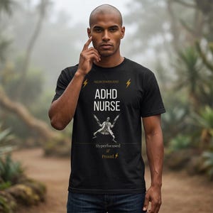 May include: A black short-sleeved t-shirt featuring the text "NEURODIVERGENT", "ADHD NURSE", "Hyperfocused & Proud" and lightning bolt icons. A graphic of a figure in a lab coat holding two syringes is centered between the text lines.