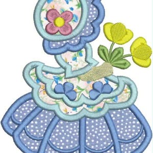 Pu&ograve; includere: Un disegno ricamato con un cappello con un motivo floreale e un fiore rosa con un centro giallo. Il disegno include un bordo smerlato azzurro e una gonna con un motivo a pois. Sono inclusi anche fiori gialli con foglie verdi.