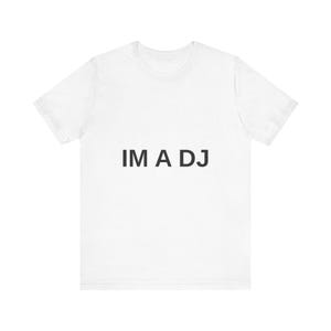 May include: A white short-sleeved t-shirt featuring the text IM A DJ printed in black capital letters across the centre of the chest. The garment has a crew neckline and a standard fit, providing a clean and simple look for everyday wear.