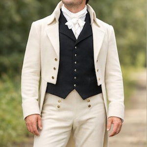 May include: A cream-colored, vintage-style coat with gold buttons, paired with a black vest and light-colored trousers. The outfit includes a white cravat. The ensemble is reminiscent of historical formal wear.
