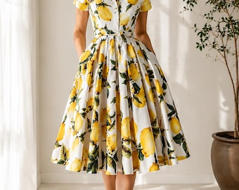 Könnte beinhalten: Ein weißes Midikleid mit einem lebendigen Druck aus gelben Zitronen und grünen Blättern. Das Kleid hat kurze Ärmel, einen Kragen, eine durchgehende Knopfleiste und einen passenden Stoffgürtel in der Taille. Der Rock ist weit und mit Taschen versehen.