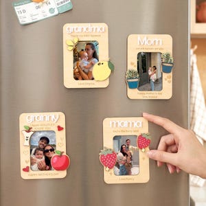 Puede incluir: Marcos de fotos de madera con las palabras "abuela", "Mamá", "abuela" y "mamá" en letras blancas. Cada marco tiene una foto y recortes decorativos de madera de un limón, cactus, manzana y fresas. Los marcos están sobre una superficie plateada.