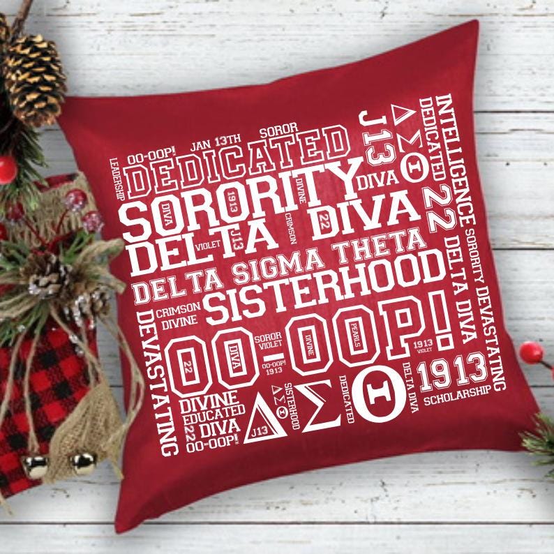 May include: A square, red decorative pillow with white text. The text includes the words "Dedicated," "Sorority," "Delta Diva," and "Sisterhood." Additional text includes "Intelligence," "Devastating," and "Scholarship."