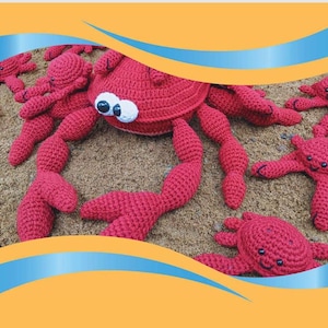 Puede incluir: Una colección de cangrejos rojos de ganchillo hechos a mano con ojos saltones. Los cangrejos están colocados sobre una superficie arenosa. Los cangrejos varían en tamaño, con el cangrejo más grande en el centro.