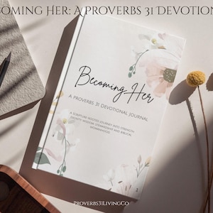 Puede incluir: Un diario devocional titulado "Becoming Her: A Proverbs 31 Devotional" con detalles florales. La portada presenta una escritura elegante y el texto "A Scripture-Rooted Journey Into Strength, Dignity, Wisdom, Stewardship, and Biblical Womanhood." También hay un lápiz y elementos decorativos.