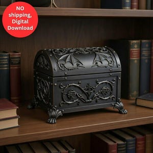 Puede incluir: Un cofre decorativo negro con detalles ornamentados, que incluyen acentos de alas de dragón en la tapa y patrones de vid. El cofre es de metal y se apoya en cuatro patas decorativas. Se exhibe en una estantería de madera con libros.