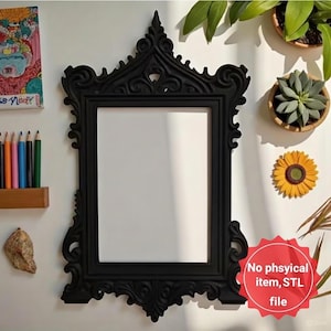Puede incluir: Un marco de fotos negro y ornamentado con una abertura rectangular. El marco tiene intrincados adornos y elementos decorativos. El texto "No physical item, STL file" es visible en una pegatina roja.