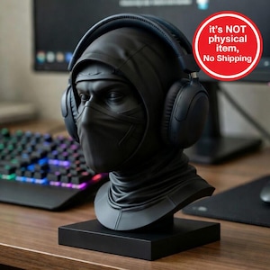 May include: A black bust of a masked figure wearing a hood and headphones. The bust is on a black rectangular base. The headphones are black with blue accents. The bust is on a wooden desk with a keyboard and monitor in the background.