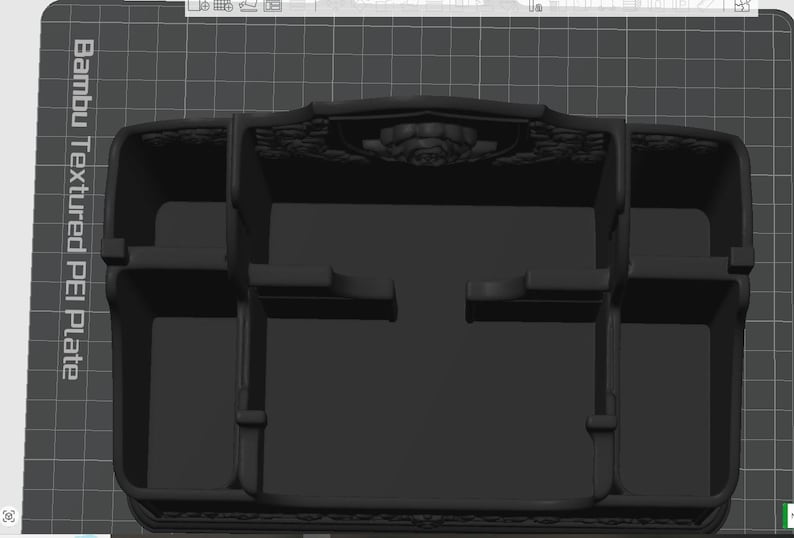 May include: A matte black desk organizer featuring multiple compartments of varying sizes for storage. The back panel displays a decorative embossed rose motif. The text Bambu Textured PEI Plate is visible on the left side of the base surface.