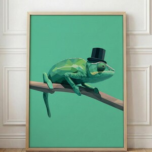 May include: A framed print showing a geometric illustration of a green chameleon wearing a black top hat. The chameleon is perched on a brown branch against a teal background. The artwork is in a wooden frame.