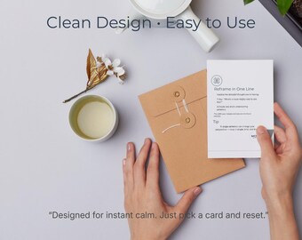 May include: A serene image with a white teapot, a teacup with tea, and a brown envelope. A card with the text "Reframe in One Line" is held by a person. The image includes the text "Clean Design • Easy to Use" and "Designed for instant calm. Just pick a card and reset."