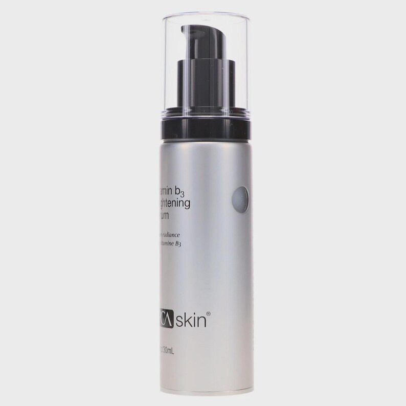 May include: A silver skincare serum bottle with a black pump and clear cap. The bottle has the text "Vitamin B3 Brightening Serum" and the brand name "CA skin". The bottle contains 30ml of product.