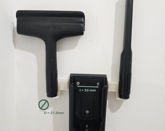 Può includere: Un set di spazzole per divani nero con una spazzola, un accessorio per fessure e una stazione di ricarica. La stazione di ricarica è larga 5 cm. La spazzola è etichettata "SOFA BRUSH".