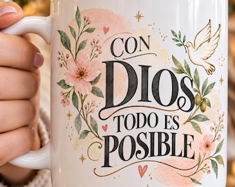 May include: A white ceramic mug featuring the black text CON DIOS TODO ES POSIBLE. The design includes watercolor-style pink flowers, green leaves, small red hearts, and a white dove carrying an olive branch, accented with gold star details.