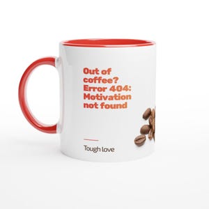 Könnte beinhalten: Weißer Kaffeebecher mit roter Innenseite und Henkel. Der Becher hat den Text "Out of coffee? Error 404: Motivation not found" in Orange, mit Kaffeebohnen an der Seite. Der Satz "Tough love" ist darunter gedruckt.