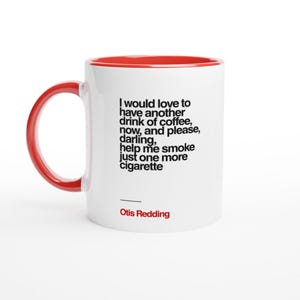 以下が含まれることがあります： 赤色の内側とハンドルが付いた白いセラミックマグ。マグには、Otis Reddingによる「I would love to have another drink of coffee, now, and please, darling, help me smoke just one more cigarette」という引用句が記載されています。