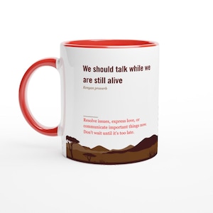 May include: White ceramic mug with a red interior and handle. The mug features the text "We should talk while we are still alive" and a Kenyan proverb. A landscape illustration is at the bottom.