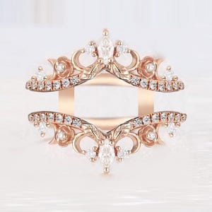 Puede incluir: Potenciador de anillo de oro rosa con intrincados diseños florales y de hojas. El potenciador presenta numerosas piedras preciosas claras pequeñas, redondas y en forma de marquesa. El anillo tiene un diseño calado delicado.