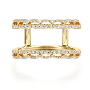 Puede incluir: Un anillo dorado con dos bandas paralelas, cada una adornada con una fila de pequeñas piedras preciosas transparentes. Las bandas están conectadas por soportes verticales, creando un diseño abierto. El anillo tiene un borde festoneado.