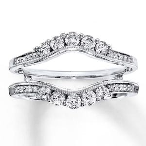 Puede incluir: Una taza de cerámica blanca con un asa negra y el texto "But First, Coffee" en un estilo manuscrito. La taza probablemente tiene 325 ml de capacidad, perfecta para una bebida matutina.