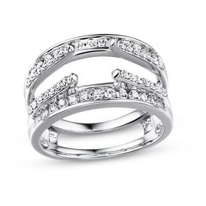 Puede incluir: Un anillo plateado con un diseño único, con múltiples bandas incrustadas con pequeñas piedras claras y brillantes. El anillo tiene un diseño abierto moderno con un acabado pulido, que refleja la luz y crea un efecto deslumbrante. Ideal para ocasiones especiales.