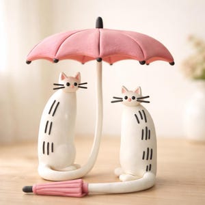 Op de afbeelding: Een set van drie keramische mokken met een gespikkelde, matte afwerking. De mokken zijn in de kleuren crème, lichtgrijs en donkergrijs. Elke mok heeft een eenvoudig, minimalistisch ontwerp en een afgeronde handgreep.