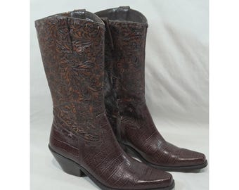 May include: A pair of dark brown mid-calf boots featuring a combination of textures. The shaft displays an intricate floral embossed pattern, while the lower foot section has a textured crocodile-skin effect. The boots have a pointed toe.