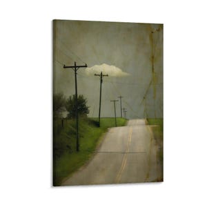 May include: A vintage-style canvas print depicts a rural road receding into the distance under a cloudy sky. Telephone poles line the road, and green grass borders the asphalt. The artwork has a textured, aged appearance.