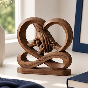 May include: A wooden sculpture in the shape of a heart and infinity symbol. The sculpture features a father's hands holding the hands of three children, with the names "Liam", "Ava", and "Sarah" engraved. The word "Daddy" is also engraved.