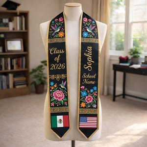 Puede incluir: Banda de graduación negra con bordados florales, detalles de colibríes y banderas. La banda está personalizada con el nombre "Sophia", el nombre de la escuela y "Clase de 2026". La banda presenta las banderas de México y Estados Unidos.