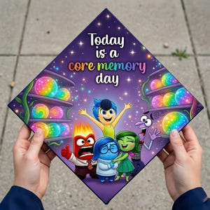 May include: A graduation cap featuring characters from the animated movie "Inside Out." The cap is purple with the text "Today is a core memory day." The design includes illustrations of the characters Joy, Sadness, Anger, Fear, and Disgust, along with colorful memory orbs.